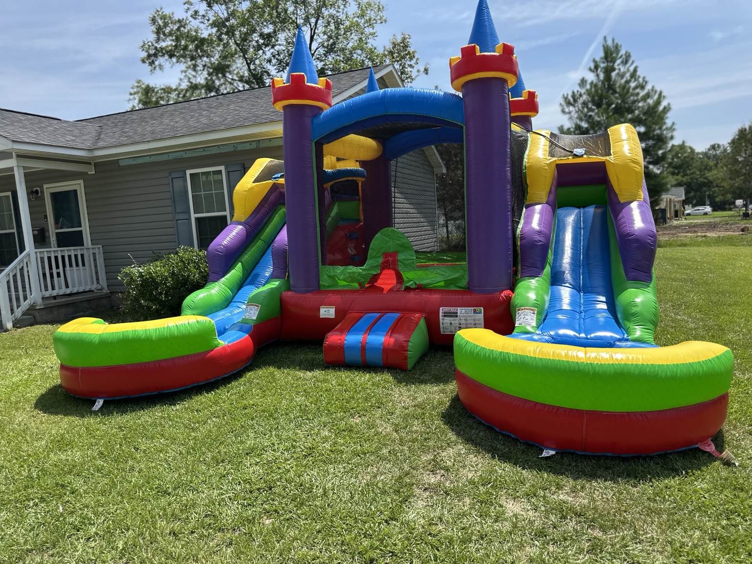 Colorful castle bounce house combo with two slides and splash pools