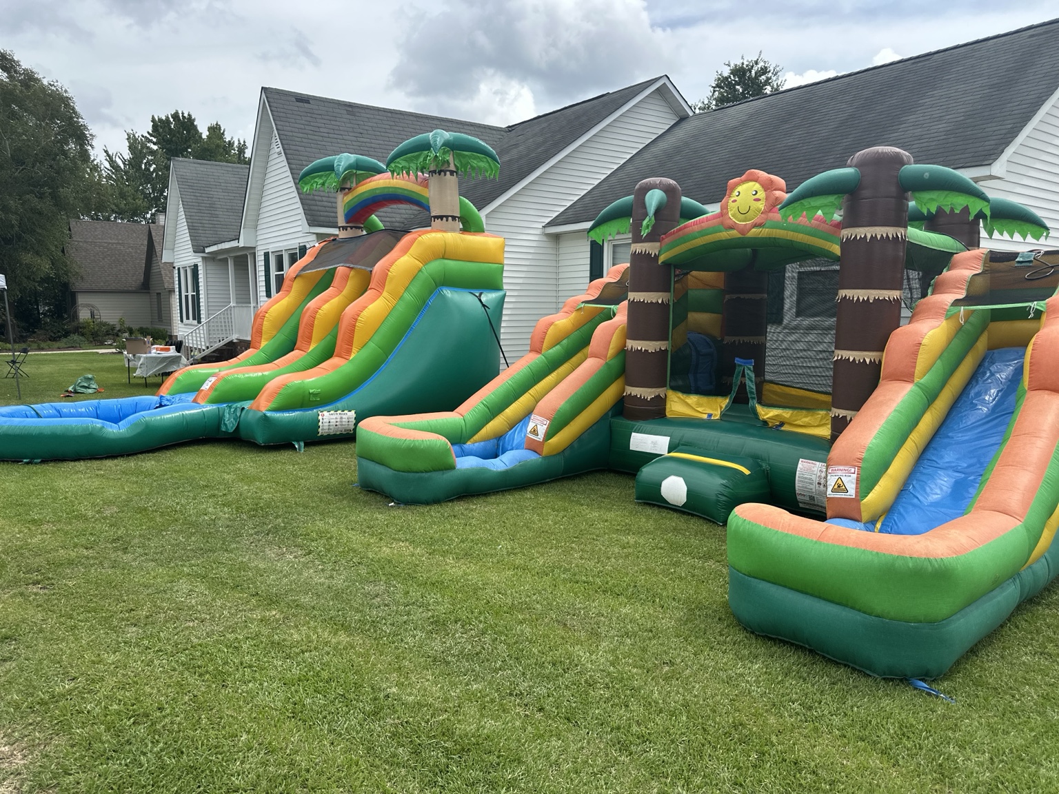 Multiple tropical inflatables set up together on a lawn